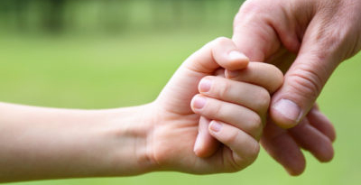 child holding adult's hand